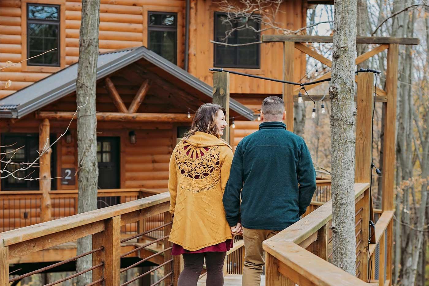 Couple walking towards a cozy cabin in the woods